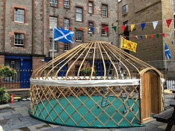 Erecting yurt on hard standing at festival Hire a Yurt for a luxury glamping weekend.