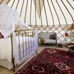 roundhouse-yurts-luxury-glamping-yurt-spanish-bed A Roundhouse Yurt with a stylish wedding night interior.